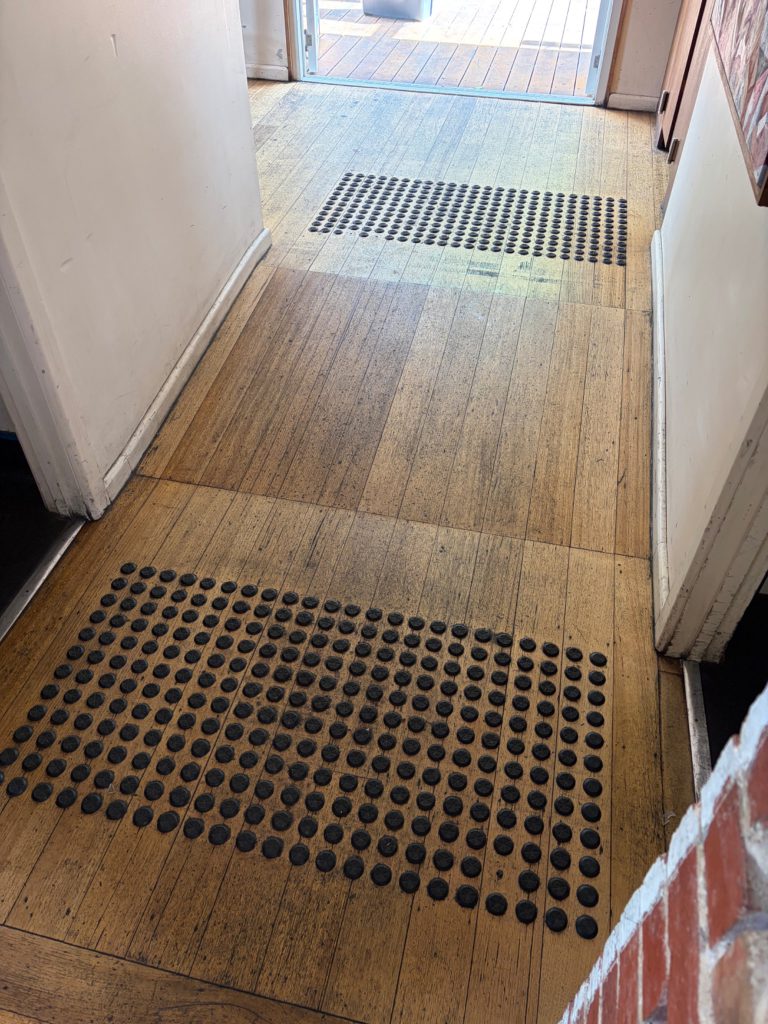 View of the timber corridor showing tactile indicators at different points along the route.